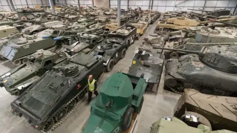 Getty Images Rows and rows of tanks parked inside what looks like a large aircraft hangar.