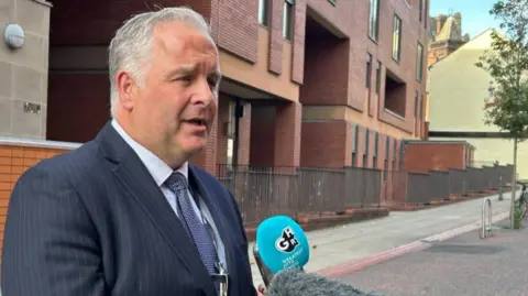 Senior investigating officer Temp Det Supt Damian Roebuck speaks to reporters outside court