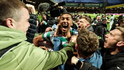 PA Media Celtic fans celebrating with players