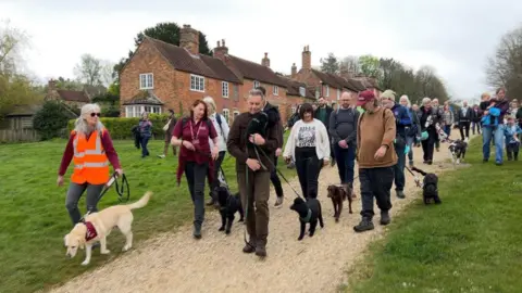BBC A group of dog walkers on a gravel path