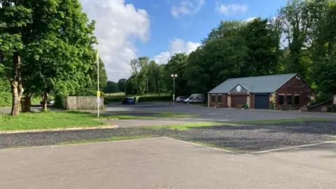 The empty car park at Yarrow Vale Country Park in Chorley. The photograph was taken on a bright sunny day.