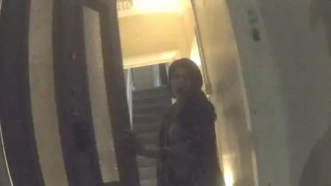 Woman opening a front door to a house