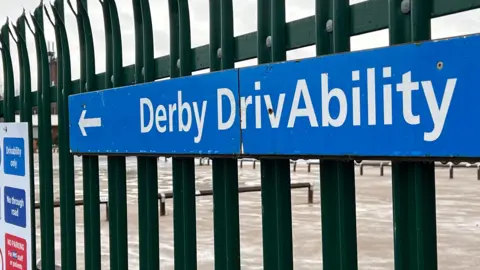 Blue sign showing the words Derby DrivAbility
