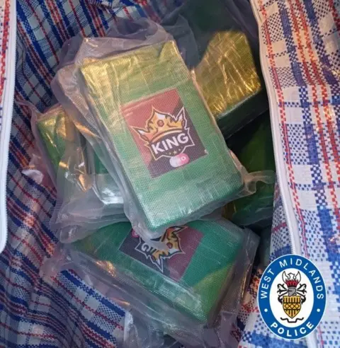 West Midlands Police A check-patterned bag with packed with are green with the word "King" on a yellow crown symbol with a red and brown background.