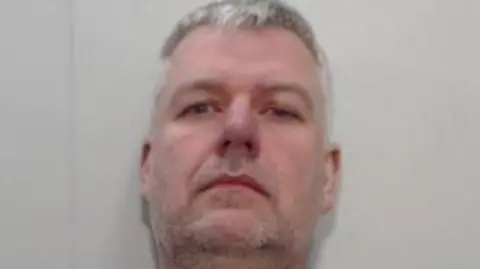 National Crime Agency A mugshot of a middle aged man with grey hair and stubble