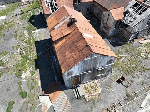 South Georgia Heritage Trust An aerial view of a wooden building with a corrugated iron roof