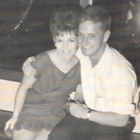 MacDonald family Ian and his wife Robyn are pictured in a black and white photo. They are sitting together. Ian and his arm around Robyn's shoulder.