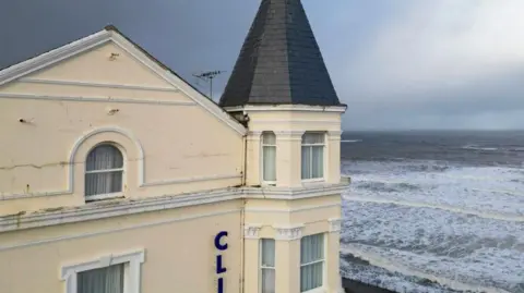 The turret of the Grade II-listed Clifton Hotel in Scarborough with the North Sea to the right of the picture - dark grey waves and sky