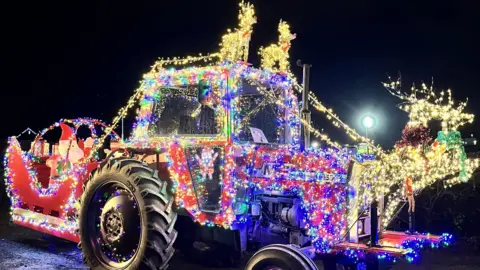A tractor at last week's Herefordshire run is covered in bright fairy lights, with illuminated reindeer at the front and on the top. A Santa sleigh has been created behind it, with a model of Father Christmas in it.