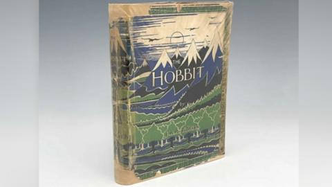The copy of The Hobbit with a partly tattered cover, with blue and black snow-capped mountains 