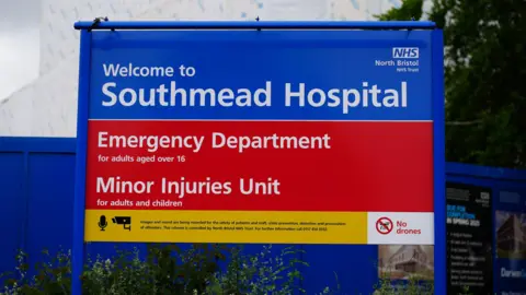 PA Media The sign for Southmead Hospital Emergency Department which is blue with red and yellow on it. 