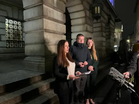 Teddy's parents pictured on the steps of Nottingham Council House next to their lawyer.