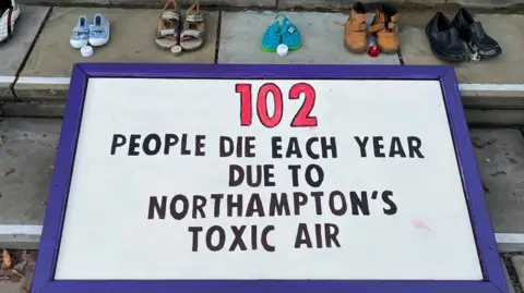 BBC White banner with black writing saying that 102 people die from Northampton's toxic air