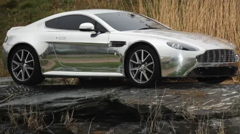An Aston Martin motor car is displayed outside the company headquarters and production plant in Gaydon