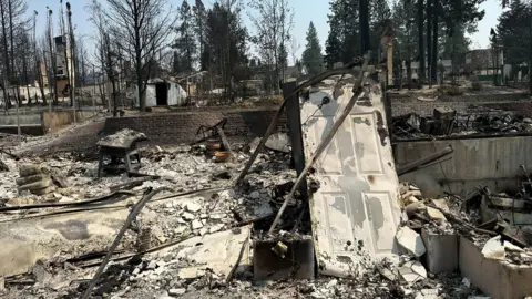 Rubble of a burned home. The door is still standing