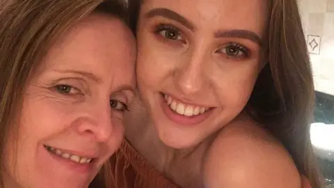 beth alker Beth taking a selfie with Emily. They're both smiling, with the picture being taken in a kitchen.