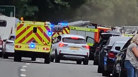 Two fire engines are seen as several cars queue on the A30
