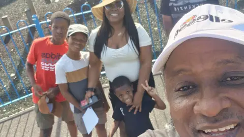 supplied A family selfie with Dad taking the picture in a cap and Mum cuddling four boys in t-shirts