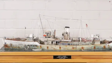 Elliott's Auctioneers Model ship at almost a metre long with model sailors painting it's hull and bow