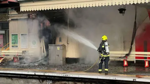 Devon and Somerset Fire and Rescue Service A Devon and Somerset Fire and Rescue Service firefighter with a hose tackling the blaze at Paignton station which caused severe damage. 