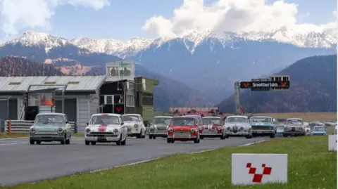 Images of cars on a race circuit with the sign Snetterton above the track, with a range of snow-capped mountains in the background. 