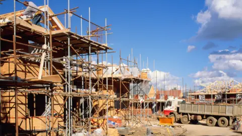 Getty Images A building site with a part-built home on the left hand side, surrounded by scaffolding and a lorry on the right hand side