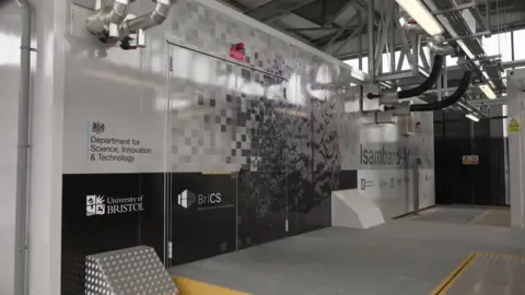 An external view of the Isambart AI computer. There is a doorway in the middle to the computer itself, and various pipes coming out of the wall