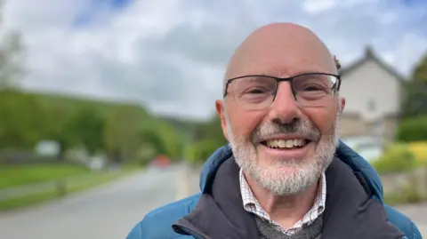 A man stood by a roadside