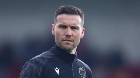 Walsall boss Mat Sadler looks on,