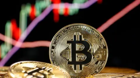 Getty Gambar bitcoin dengan grafik naik tajam di belakangnya