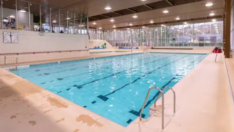 A large pool, housed in a modern leisure hub. 