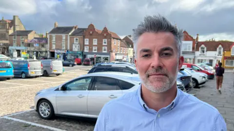 York and North Yorkshire's Labour mayor David Skaith wearing a blue shirt and standing on Thirsk's high street