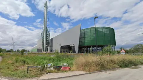 Google Viridor's recycling facility in Avonmouth. The building is gray and green in color and has a tall structure in front.