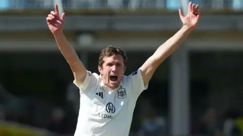 Will Williams with both hands aloft appealing for a wicket for Glocuestershire