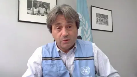 A headshot of the UN coordinator who is seated and mid-speaking