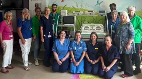 Mid and South Essex NHS Foundation Trust Nurses and doctors standing around the new neonatal transport incubator at Broomfield Hospital in Essex