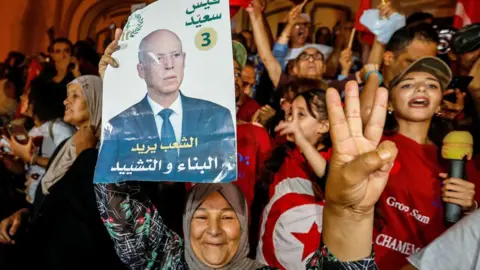 Supporters of Tunisian President Kais Saied celebrate after exit poll shows Saied won the presidential election in Tunis, Tunisia - 6 October 2024