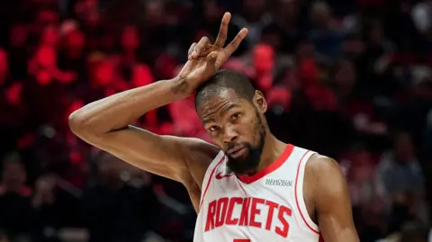 Kevin Durant makes a 'V' sign with his fingers above his head