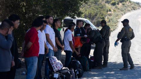 Migrants being processed by border officials near San Diego in May
