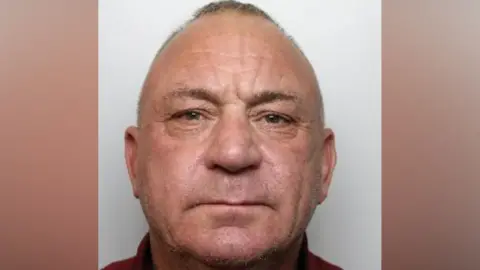 A police mugshot of Michael Tyrrell. He is 55, balding and has brown eyes.