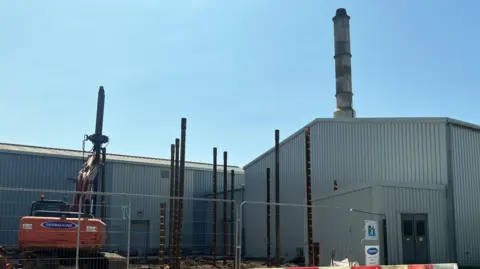 BBC grey incinerator building with work beside it at Longue Hougue