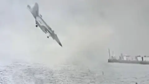 A US fighter jet is seen nose down moments before it crashes into the San Diego Bay.