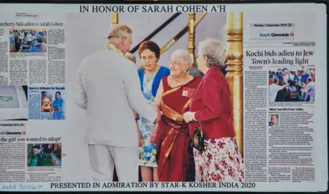 Dinesh Madhavan A collection of newspaper articles on Sarah Cohen's life and death. In the centre is a photo of her meeting the then Prince Charles in 2013
