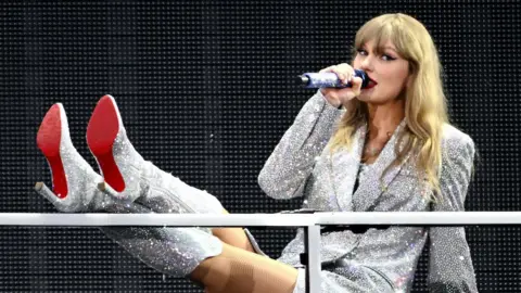 Getty Images Taylor Swift in a sparkly dress and matching boots