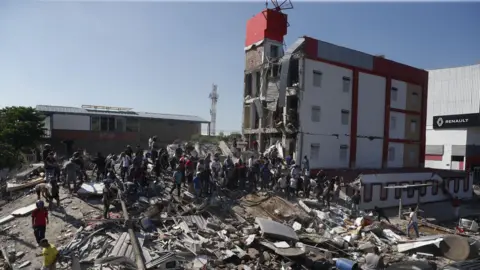 ERNESTO GUZMAN/EPA People walk through the rubble of a collapsed building after an earthquake in Cali, Colombia, 10 August 2026. At least 20 buildings sustained severe damage as a result of the 7.4-magnitude earthquake that shook most of the country, with its epicenter in the Pacific region.
7.4-magnitude earthquake hits Colombia, Cali
