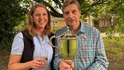 CLA Neil Anderson holding a trophy and Debbie Reynolds of the Kent Farming & Wildlife Advisory Group