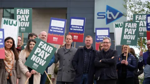 PA Media A group of STV reporters and staff on strike outside the broadcaster's office in Glasgow.