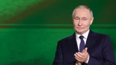 Russia's leader in a suit and white tie, his hands together, with a green background