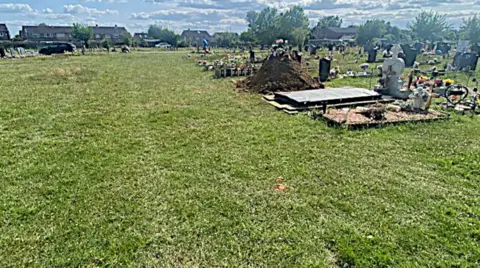 Supplied A wider picture of the cemetery shows an expanse of grass on the left and the grave and newly dug earth on the right hand side.