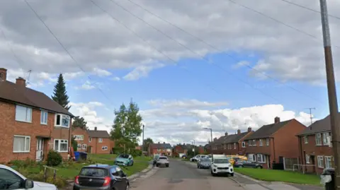 Google A road with houses either side and blue sky above